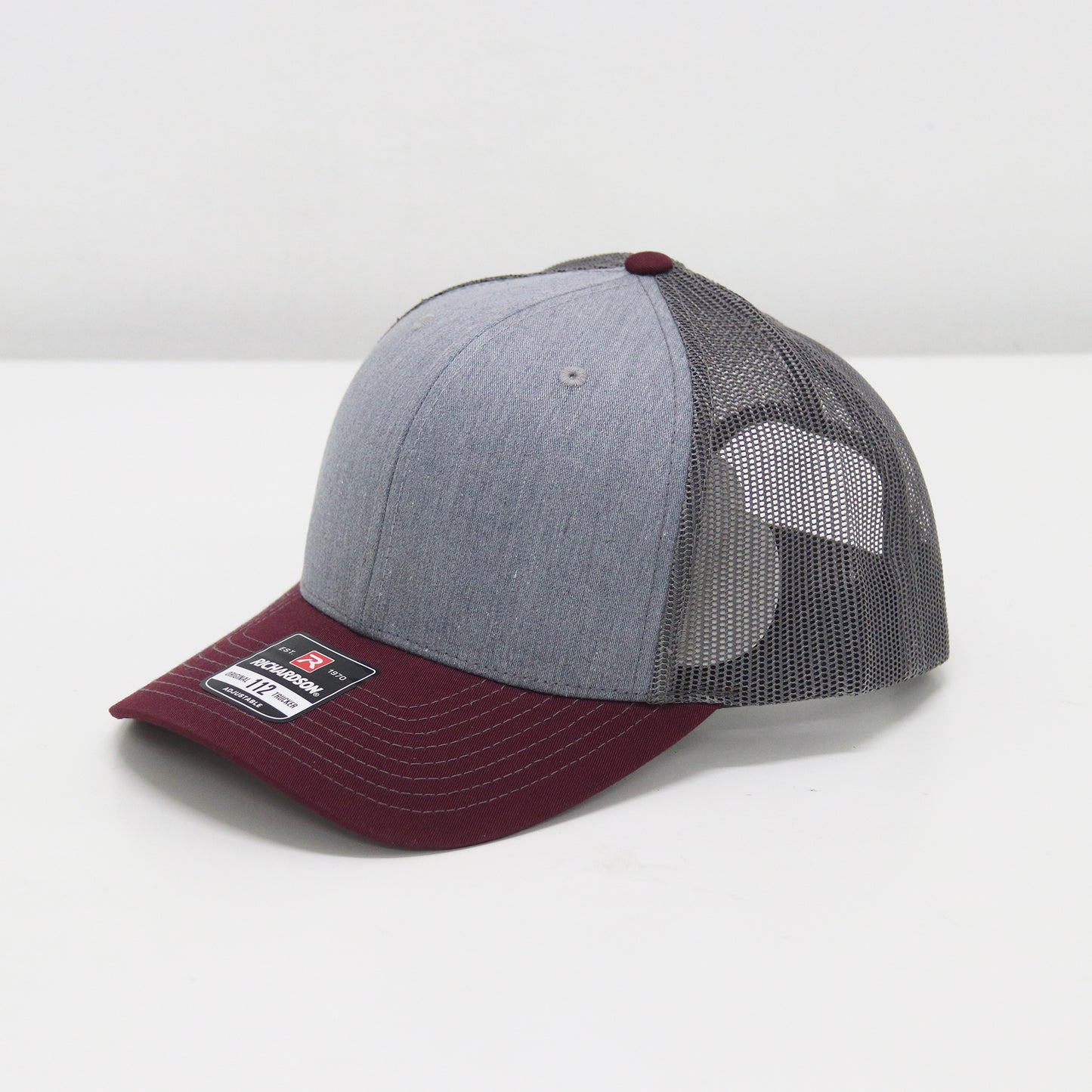 Gray and maroon baseball cap with mesh back on a white background