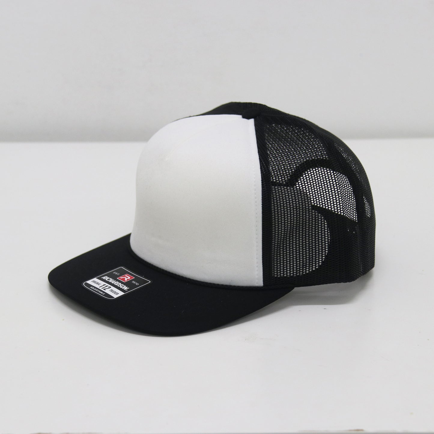 Black and white cap with mesh back on a white background