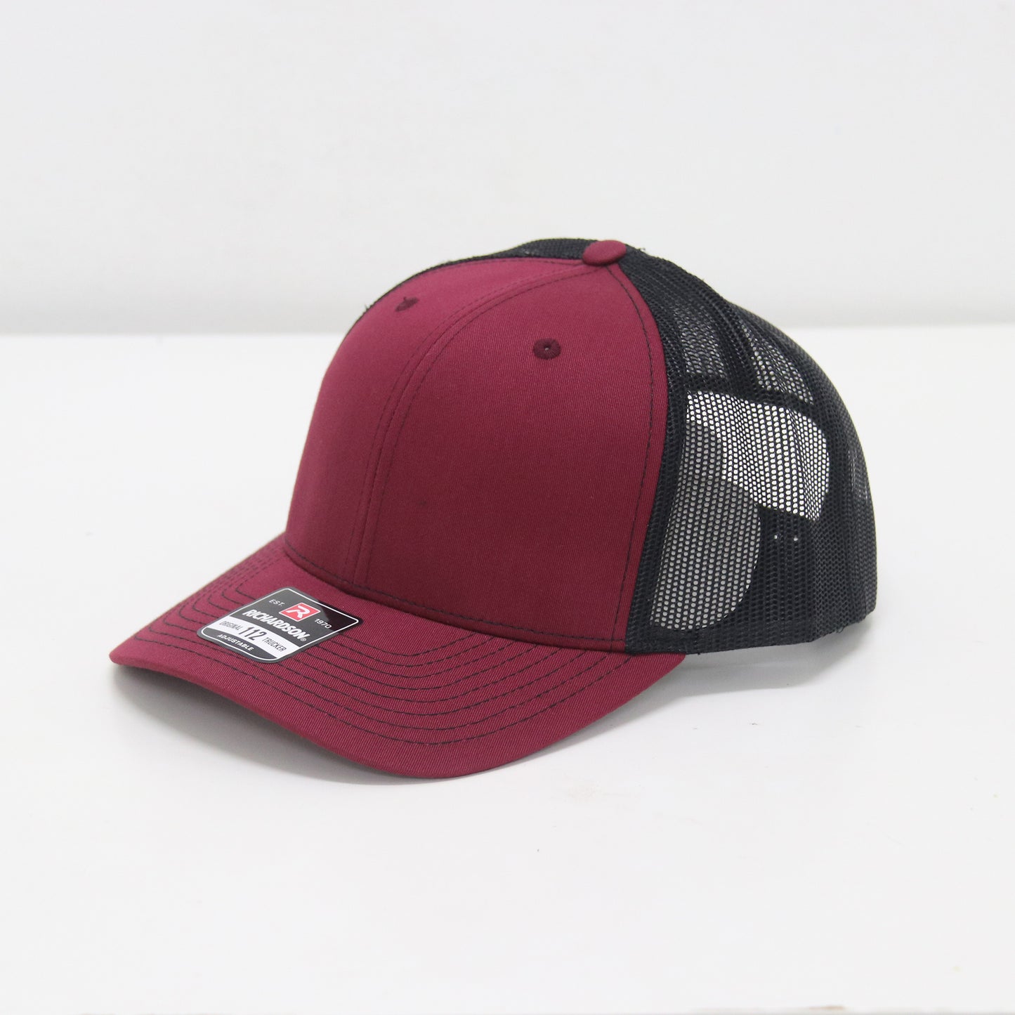 Red and black cap with mesh back on a white background
