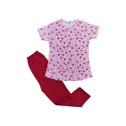 Pink pajama top with red lip print and red pants on a white background