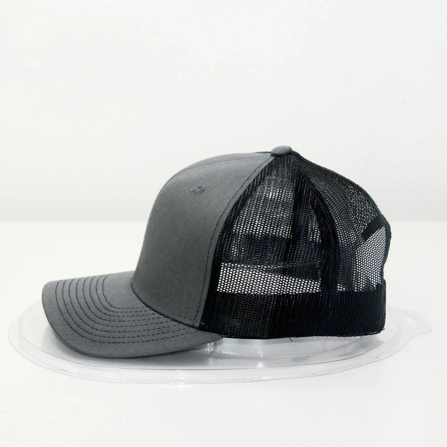 A gray trucker cap with a curved brim and a mesh back.