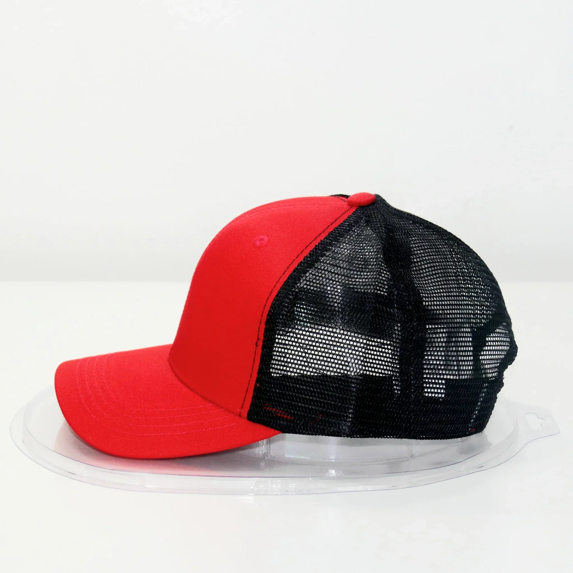 A red and black trucker cap with a curved brim, displayed against a white background.