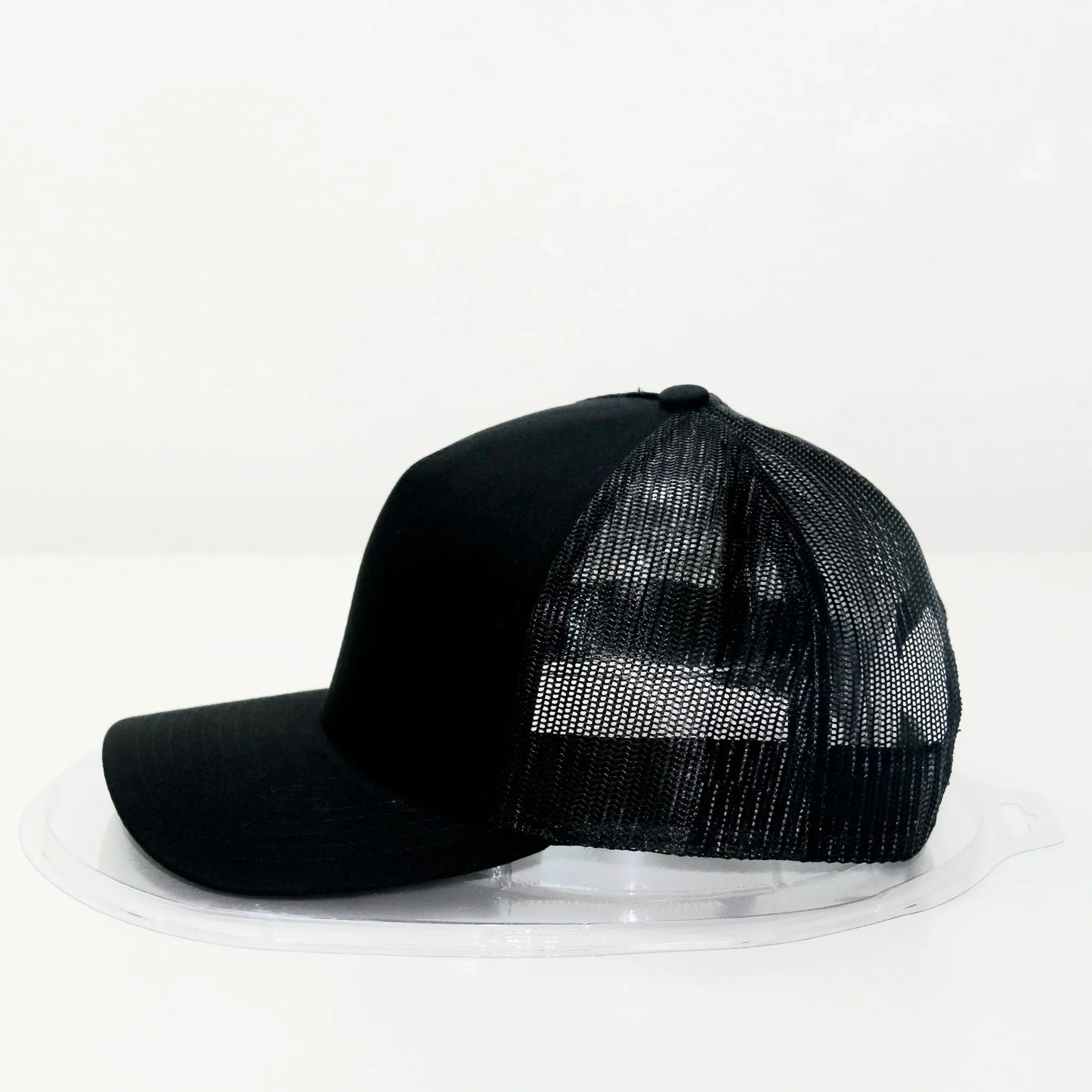 A black trucker cap with a curved brim and a mesh back.