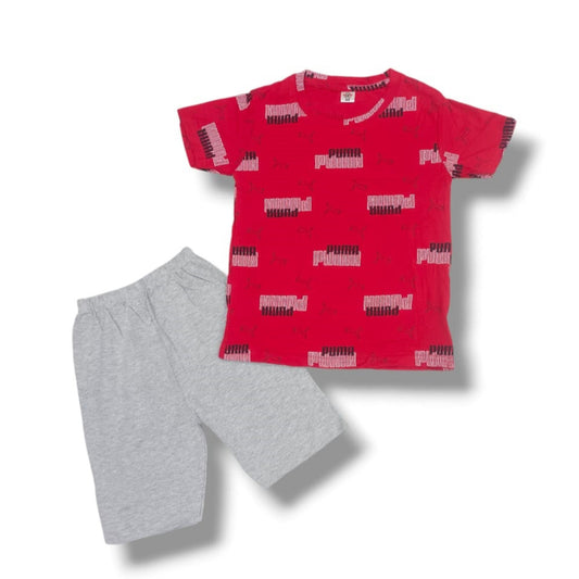 Red t-shirt with black and white pattern and gray shorts on a white background