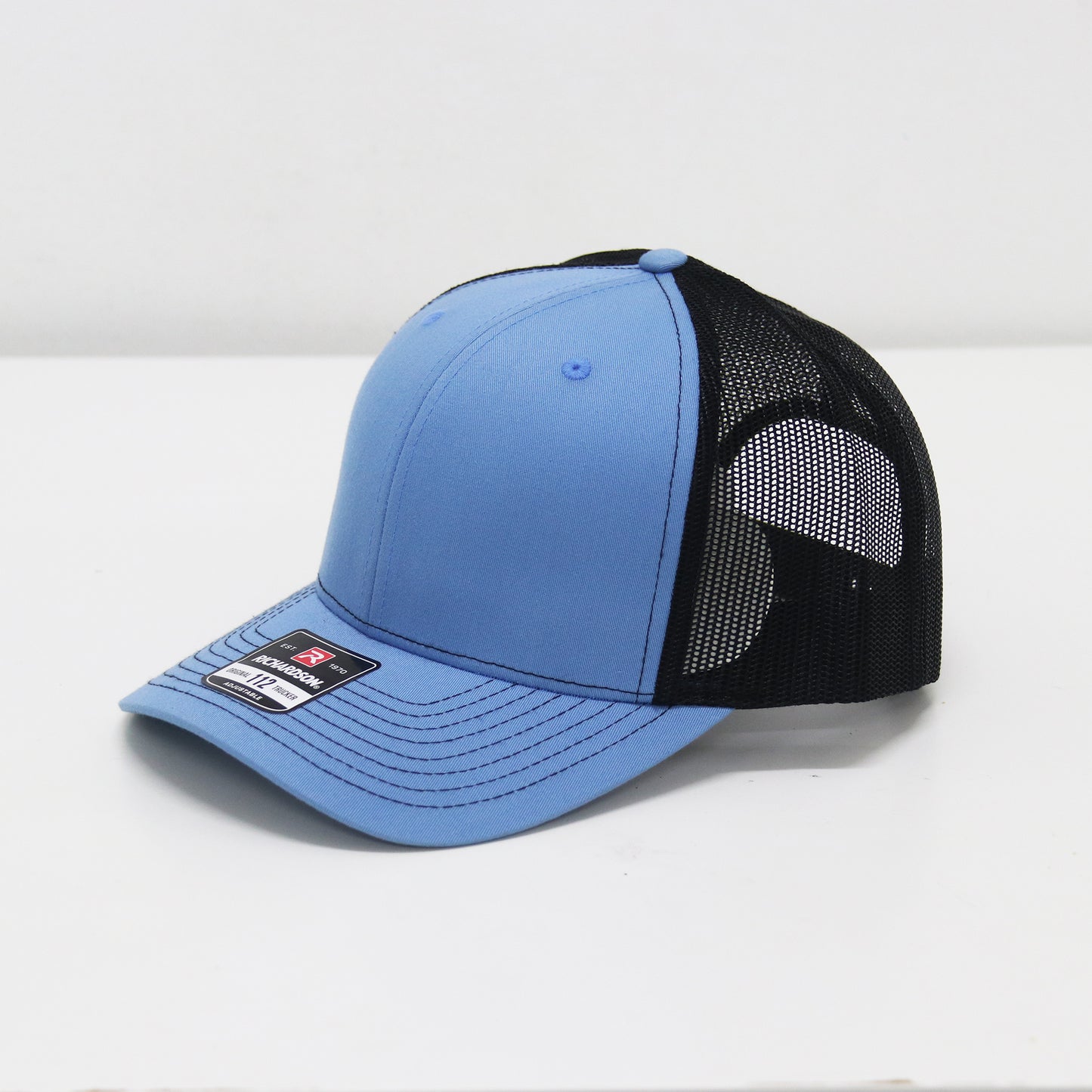 Blue and black cap with mesh back on a white background