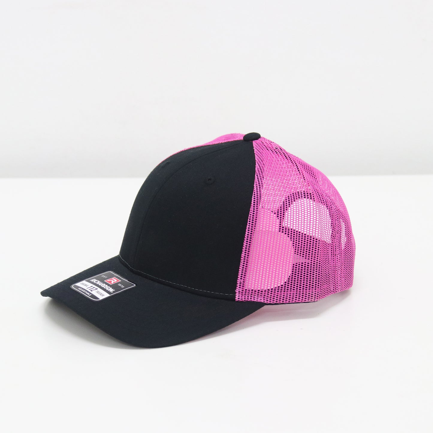 Black and pink cap with mesh back on a white background
