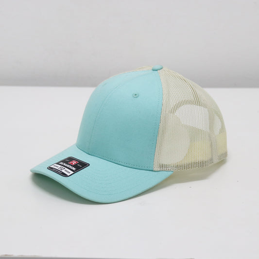 Turquoise baseball cap with beige mesh back on a white surface