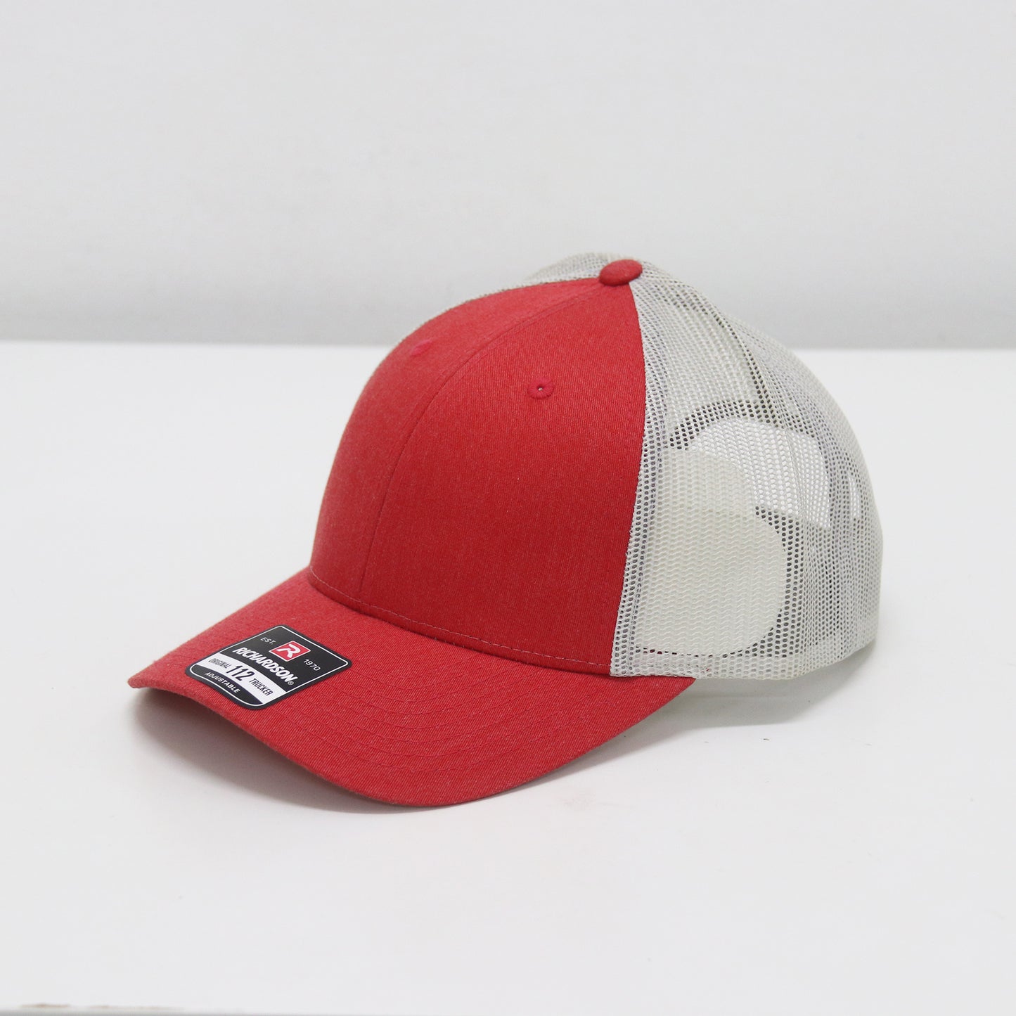 Red and white cap with mesh back on a white background