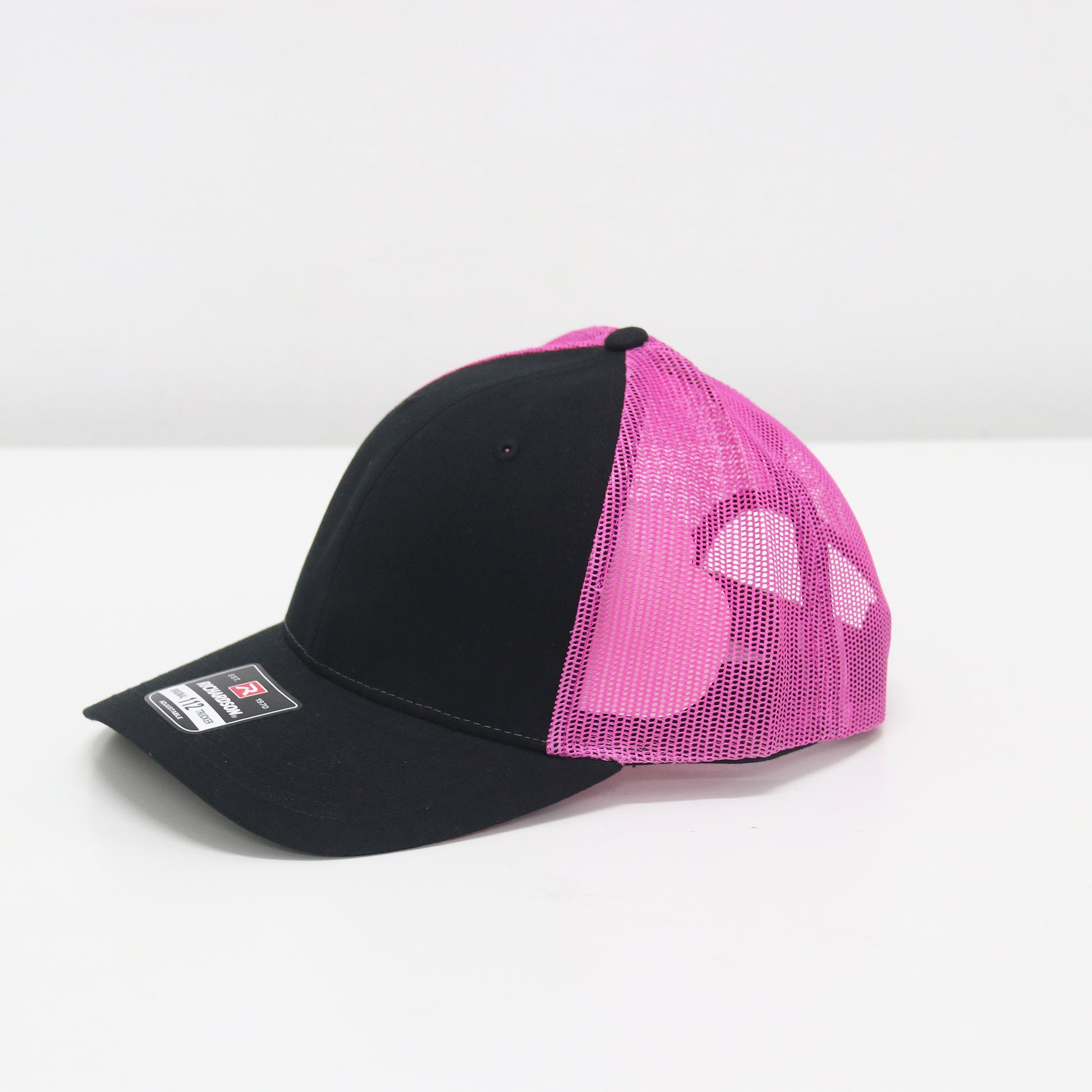 Black and pink cap with mesh back on a white background