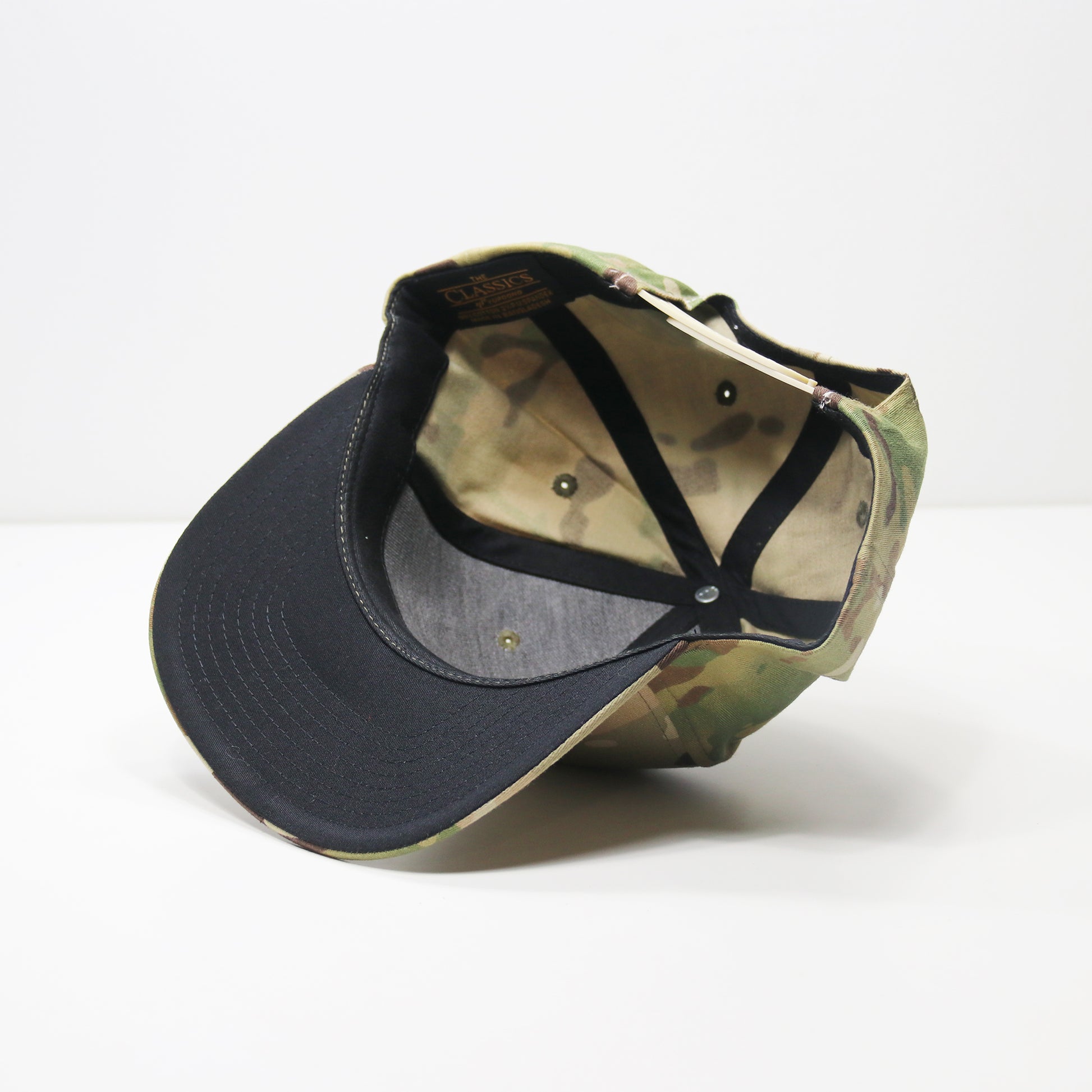 Two baseball caps, one black and one camouflage, on a white background