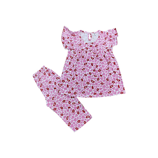 Pink pajama set with red leopard print on a white background