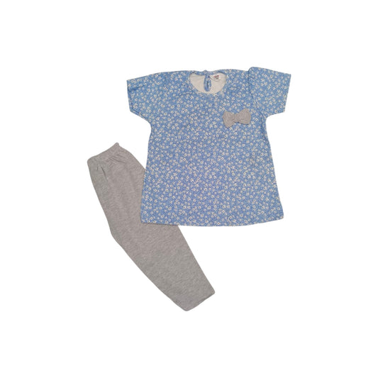 Children's outfit with blue floral top and gray pants on a white background